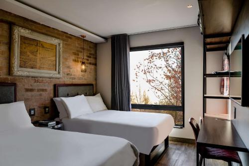 a hotel room with two beds and a window at Hotel Perte at Montecasino in Johannesburg