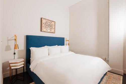 紐奧良的住宿－Sonder The Gallier，卧室配有一张白色大床和一把椅子