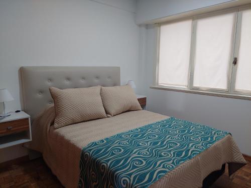 a bedroom with a bed and two windows at Depto. Chauvin in Mar del Plata