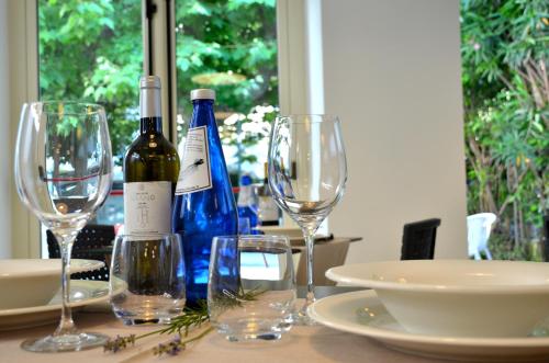 a table with two bottles of wine and glasses at Petit Hotel in Lido di Camaiore