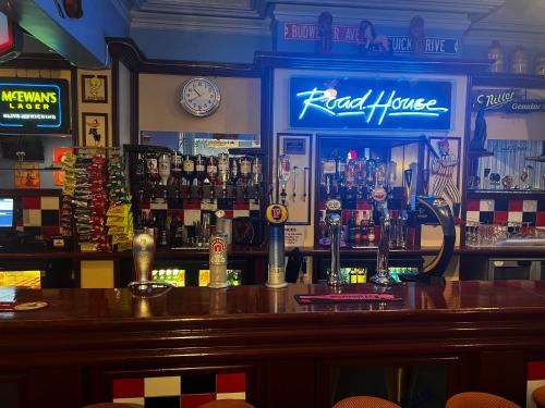 a bar in a pub with a counter with alcohol at The Roadhouse Hotel in Carlisle