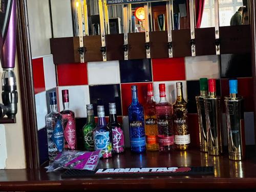 a group of bottles of alcohol sitting on a shelf at The Roadhouse Hotel in Carlisle