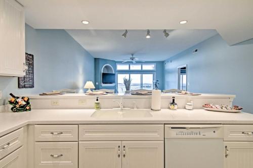 a kitchen with a sink and a blue wall at Beautiful Waterfront Condo with Community Pool! in Crisfield