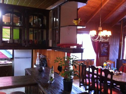 a dining room with a wooden table and chairs at Hostal el Nogal Pucón in Pucón