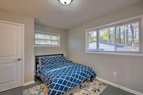 a bedroom with a bed with a blue comforter and two windows at Central Location! World Cup ATL HQ 5 Mi to Stadium in Atlanta