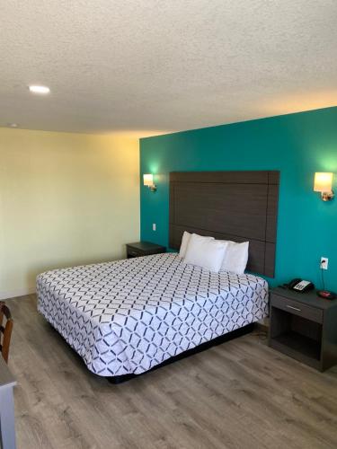 um quarto com uma cama e uma parede azul em Gila Bend Lodge em Gila Bend