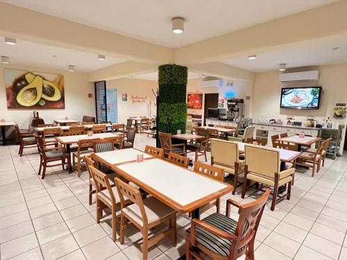 a restaurant with wooden tables and chairs in a room at Neo Business Hotel in Culiac&aacute;n