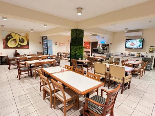 a restaurant with wooden tables and chairs in a room at Neo Business Hotel in Culiacán