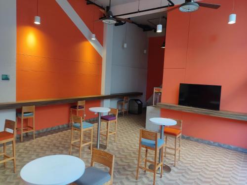 a room with tables and chairs and a flat screen tv at LivinnX Barranquilla in Barranquilla