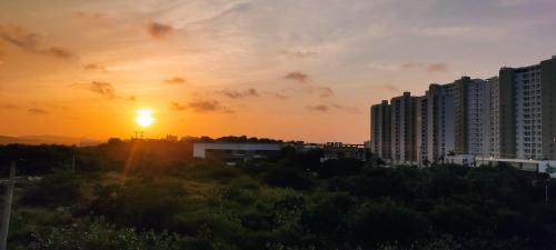 a sunset over a city with tall buildings at LivinnX Barranquilla in Barranquilla