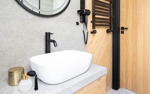 a bathroom with a white sink and a mirror at Wrota Chałubińskiego in Zakopane