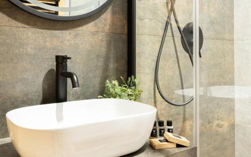 a bathroom with a white sink and a shower at Wrota Chałubińskiego in Zakopane