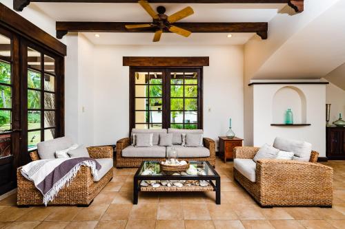 ein Wohnzimmer mit 2 Sofas und einem Tisch in der Unterkunft Villa Estrella del Mar in Tamarindo