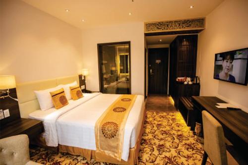 a hotel room with a large bed and a desk at ELIZABETH HOTEL in Thu Dau Mot