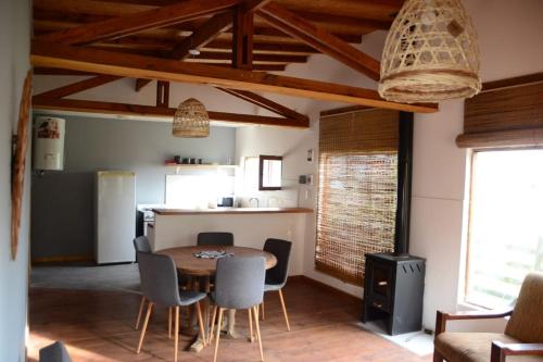 cocina y comedor con mesa y sillas en Cabaña en la Colina en Sierra de los Padres