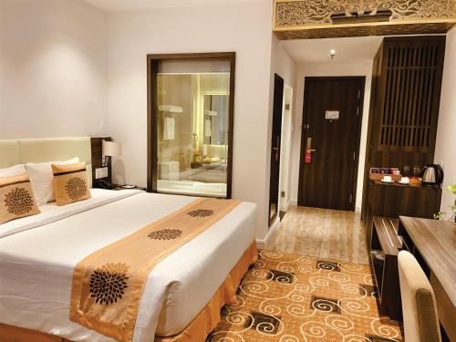 a bedroom with a large bed and a bathroom at ELIZABETH HOTEL in Thu Dau Mot