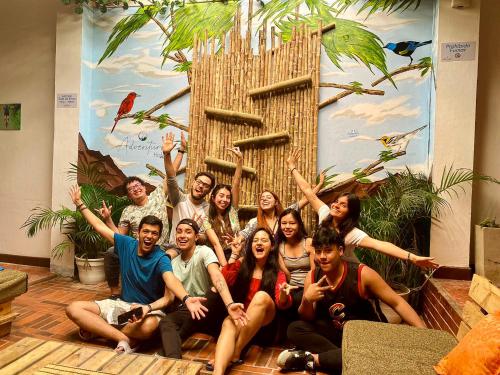 a group of people posing for a picture in front of a wall at ADVENTURE Hostel in San Gil
