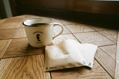 a cup of coffee and a piece of paper on a table at Hakonowa in Hakone