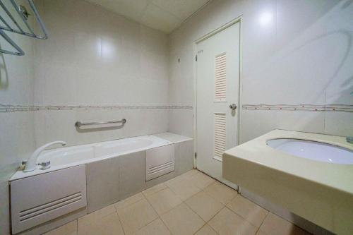 a white bathroom with a tub and a sink at Sunny Homestay in Jian