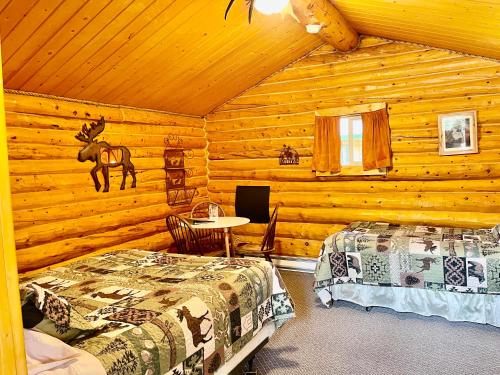 a bedroom with two beds in a log cabin at Carlo Creek Cabins in McKinley Park