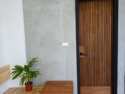 a wooden door in a room with a potted plant at Summerflow Hostel in Xiaoliuqiu