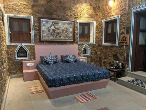 um quarto com uma cama numa parede de pedra em Prabhu Niwas Jaipur 45 km on Delhi Road em Jaipur