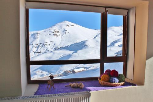 okno z widokiem na pokrytą śniegiem górę w obiekcie Valle Nevado Vip Apartment Ski Out-In w mieście Valle Nevado