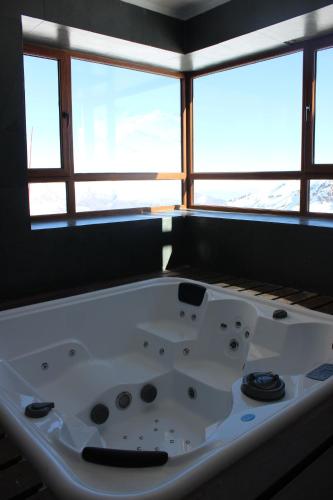 a white bath tub in a room with windows at Valle Nevado Vip Apartment Ski Out-In in Valle Nevado