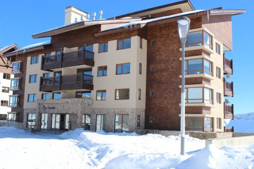 budynek z śniegiem przed nim w obiekcie Valle Nevado Vip Apartment Ski Out-In w mieście Valle Nevado