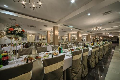 a banquet hall with white tables and chairs and flowers at Hotel Stara Fabryka in Małogoszcz