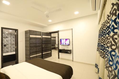 a bedroom with a bed and a tv on the wall at Imperial Grande Resort in Lonavala