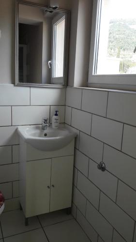 La salle de bains blanche est pourvue d'un lavabo et d'un miroir. dans l'établissement Bed and Breakfast BLUE in BLUE, Room GREEN +, à Komiža