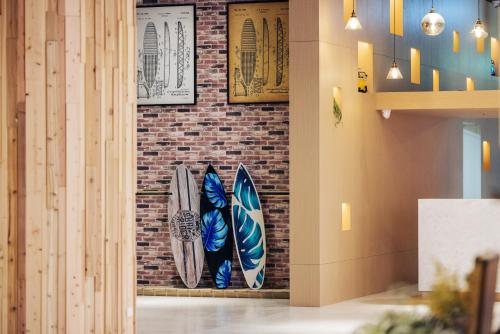 a wall with surfboards hanging on a brick wall at OA HOTEL Wushih Marina in Toucheng