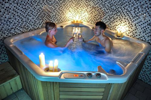 a man and a woman sitting in a bathtub at Hotel Crocus in Vysoké Tatry