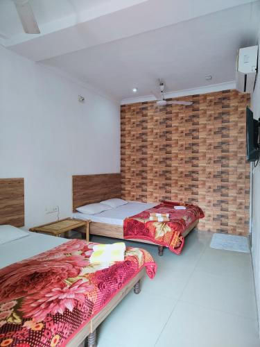 a bedroom with two beds and a brick wall at Hotel Heritage High in Udaipur