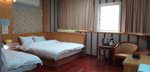 a hotel room with a bed and a window at Jin Ge hot spring Hotel in Jiaoxi