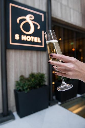 a person holding a glass of wine at S Hotel Boutique Thessaloniki in Thessaloniki