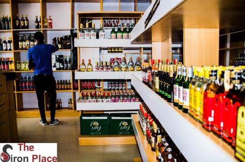 a man is standing in a liquor store aisle at The Siron Place Hotel in Ongata Rongai 