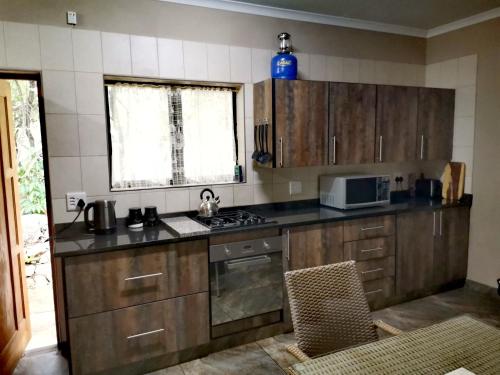 a kitchen with wooden cabinets and a stove top oven at BUFFALO in Marloth Park