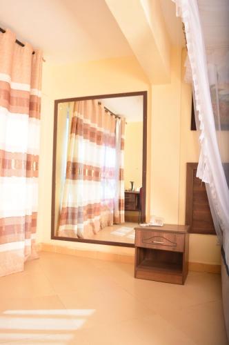 a bathroom with a large mirror in a room at The Siron Place Hotel in Ongata Rongai 