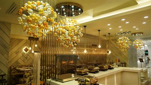 a store with a large chandelier and gold balloons at De Glance Hotel in Surat