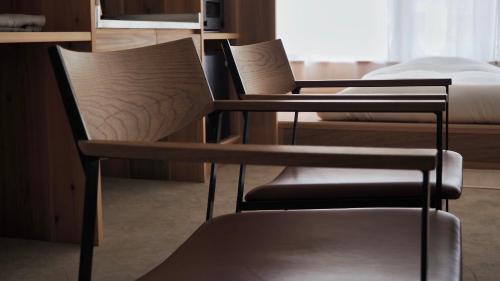 - deux chaises et un lit dans une chambre dans l'établissement HUB INN, à Onomichi