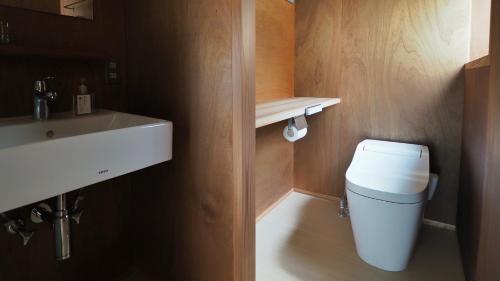 a bathroom with a white toilet and a sink at HUB INN in Onomichi