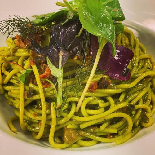 a plate of spaghetti with greens on top of it at Gasthaus Rössle in Nenzing