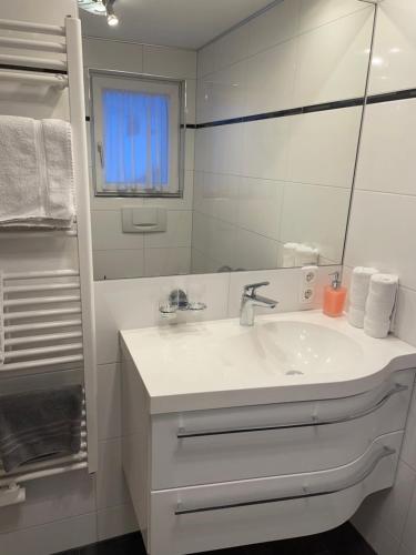 a white bathroom with a sink and a mirror at Pension Christine in Gaschurn