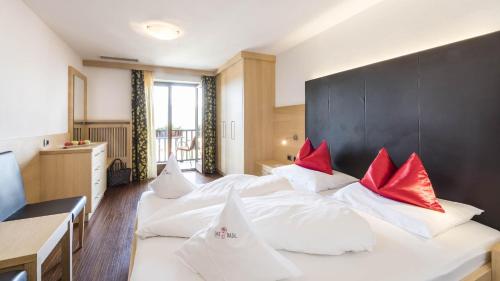 a bedroom with two white beds with red pillows at DAS BADL - Smart Retreat AO in Caldaro
