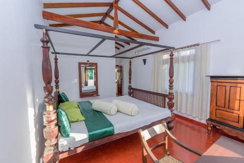 a bedroom with a canopy bed with a mirror at Villa Guru Hikkaduwa in Hikkaduwa