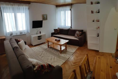 uma sala de estar com um sofá e uma mesa em Jahorina apartman Košuta D5 em Jahorina