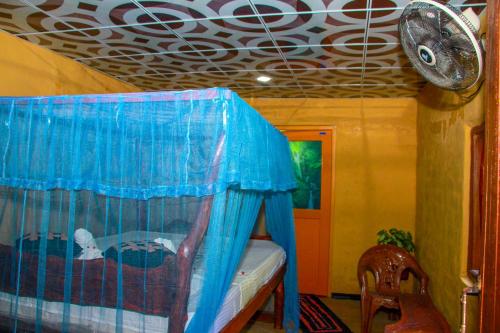 a bedroom with a bed with a blue curtain at Relax Nature Villa in Sigiriya