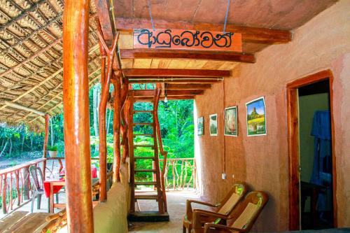 a room with a balcony with chairs and a ladder at Relax Nature Villa in Sigiriya